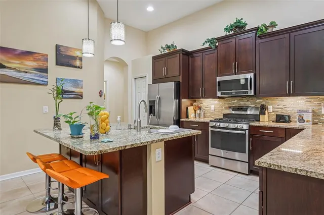 a kitchen with kitchen island granite countertop a sink counter and chairs