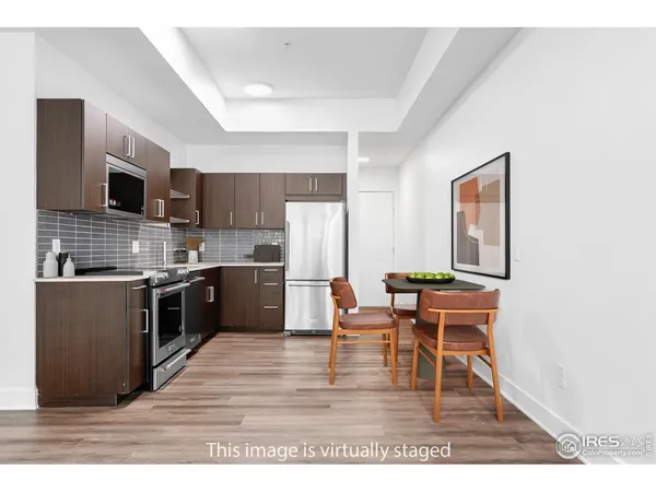a kitchen with stainless steel appliances kitchen island granite countertop a sink table and chairs