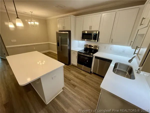 a kitchen with a sink a microwave a refrigerator and cabinets