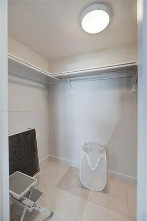 a room with a chair and potted plant