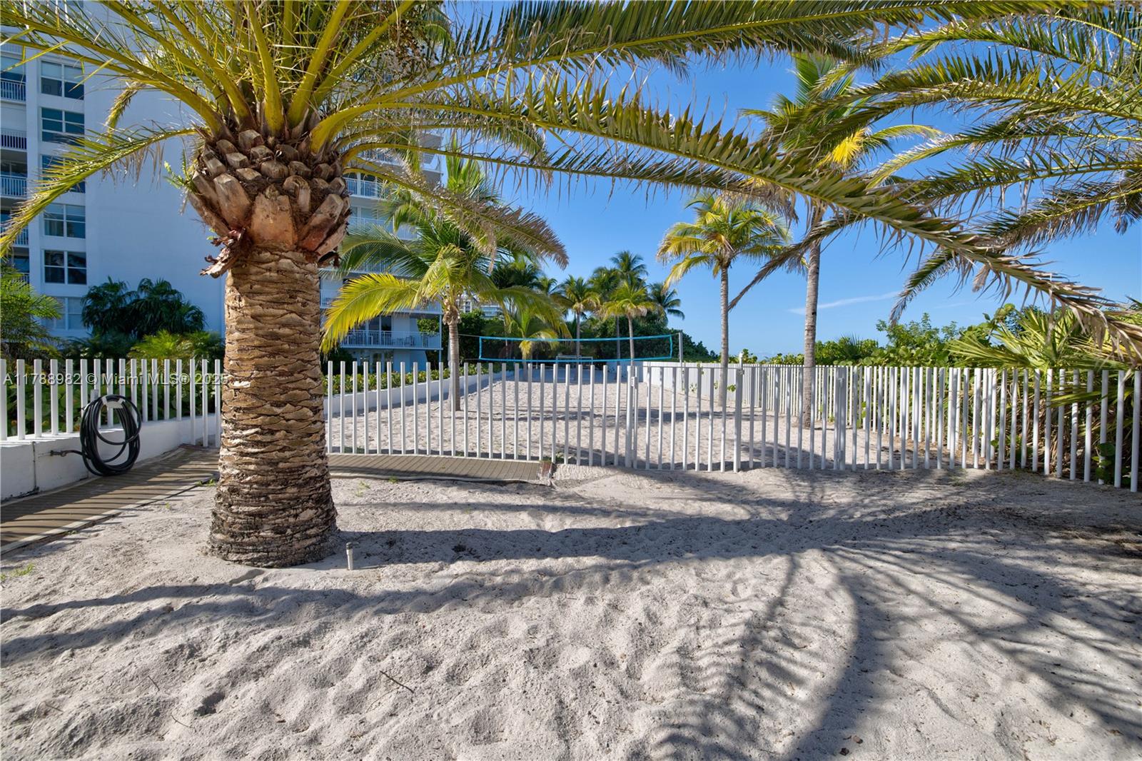 609 Ocean Drive, Unit 6H Key Biscayne, FL 33149 - Photo 31 of 32 a view of a house with a small yard and wooden fence