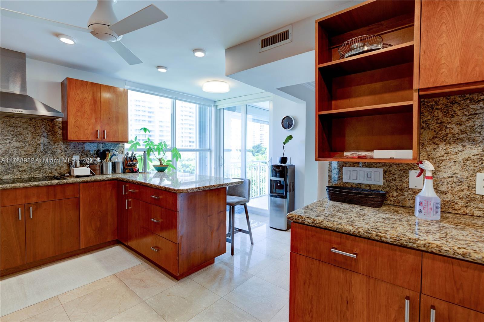 609 Ocean Drive, Unit 6H Key Biscayne, FL 33149 - Photo 5 of 32 a kitchen with granite countertop a stove a sink and a microwave