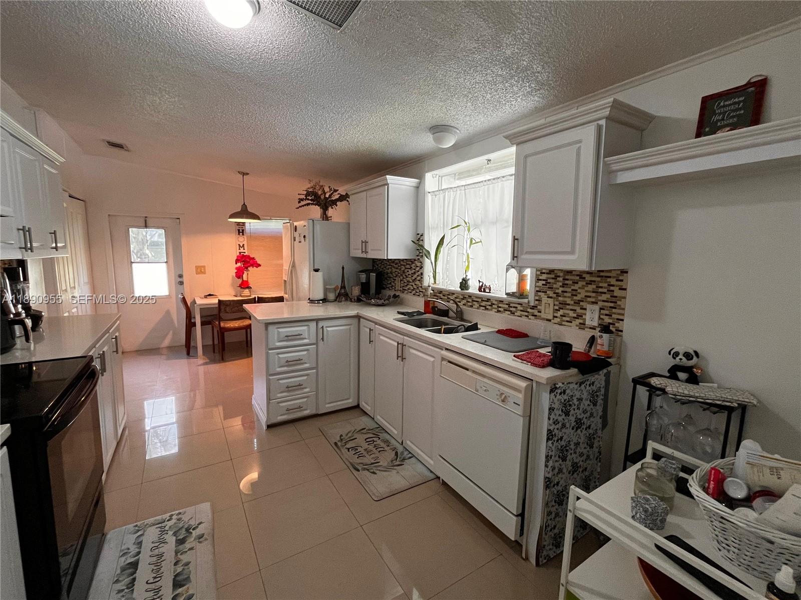 909 Southwest 131st Way Davie, FL 33325 - Photo 17 of 36 a kitchen with a stove a sink and cabinets