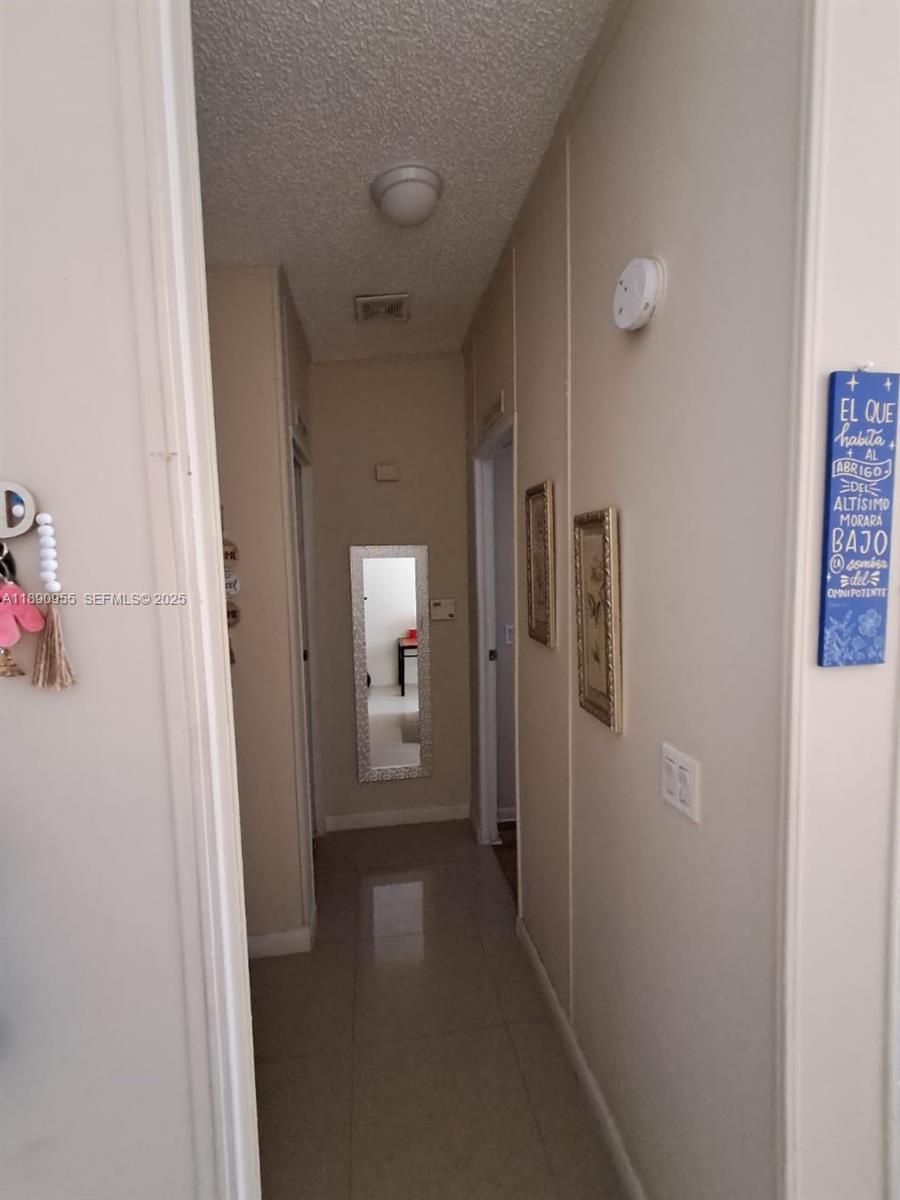 909 Southwest 131st Way Davie, FL 33325 - Photo 20 of 36 a view of a hallway with wooden floor and a bathroom