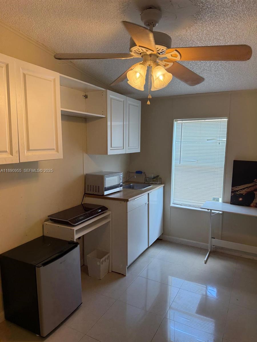 909 Southwest 131st Way Davie, FL 33325 - Photo 21 of 36 a kitchen that has a microwave and a stove