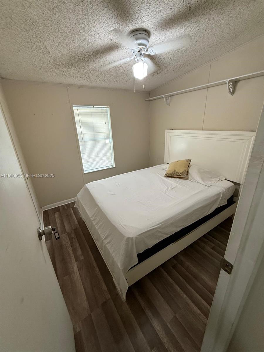 909 Southwest 131st Way Davie, FL 33325 - Photo 25 of 36 a bedroom with a bed and a chandelier