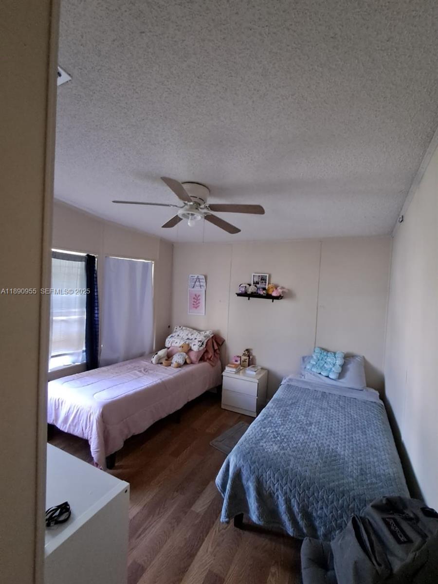 909 Southwest 131st Way Davie, FL 33325 - Photo 27 of 36 a bedroom with two beds and a chandelier
