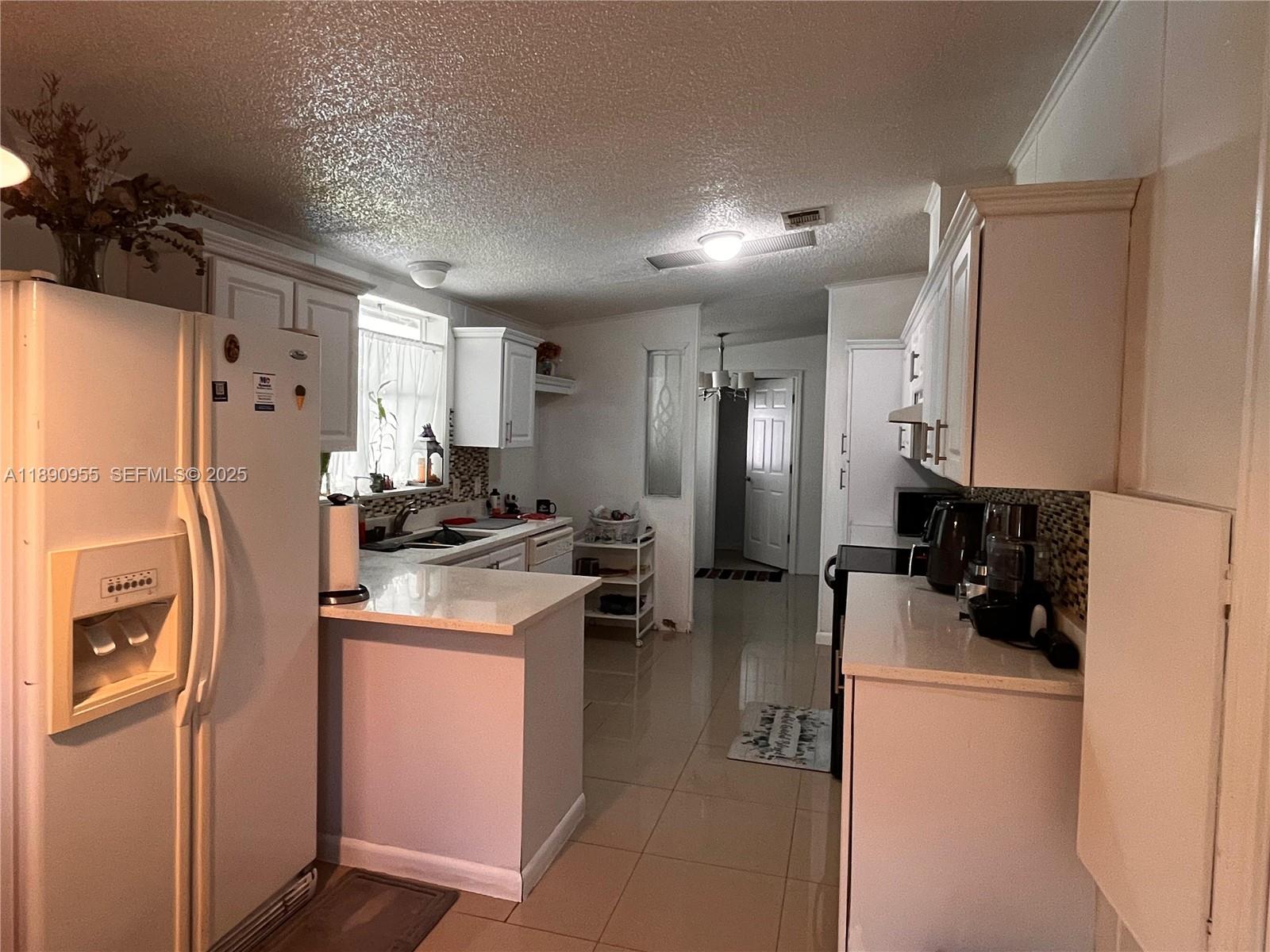 909 Southwest 131st Way Davie, FL 33325 - Photo 3 of 36 a kitchen with a refrigerator a sink and dishwasher