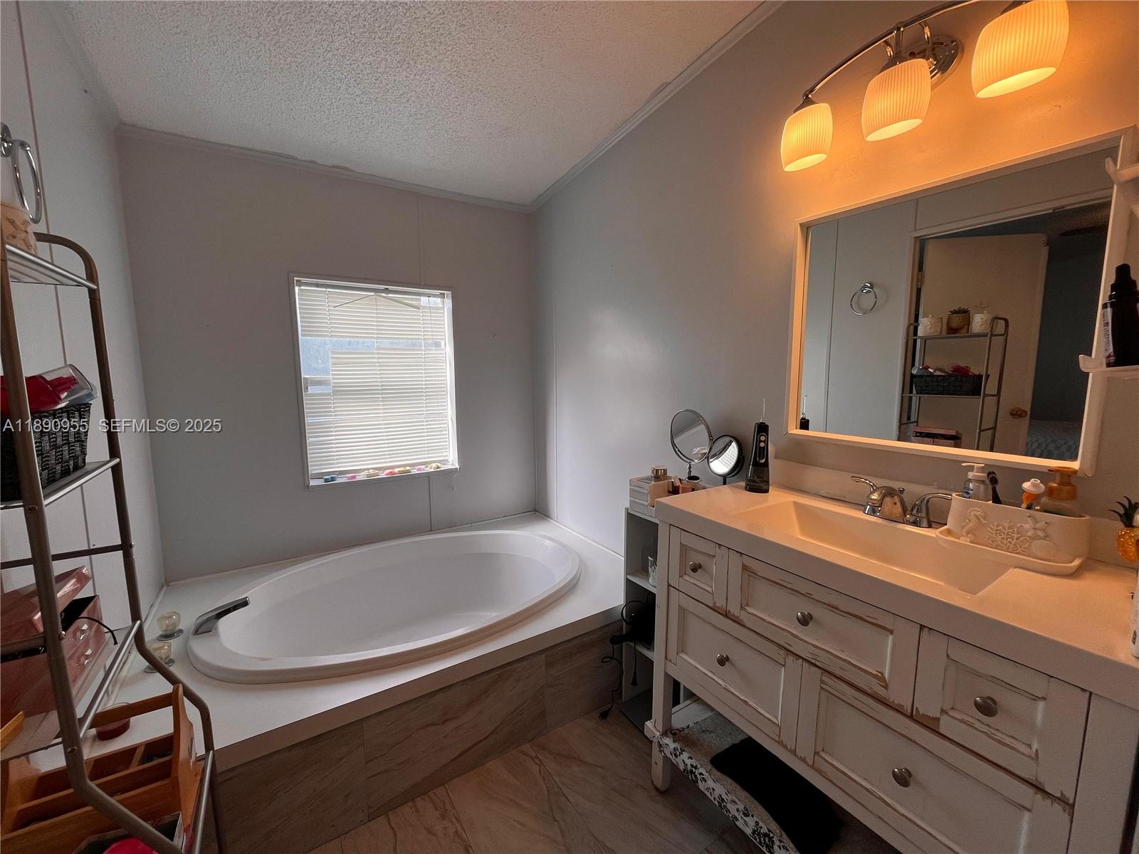 909 Southwest 131st Way Davie, FL 33325 - Photo 4 of 36 a bathroom with a tub sink and mirror