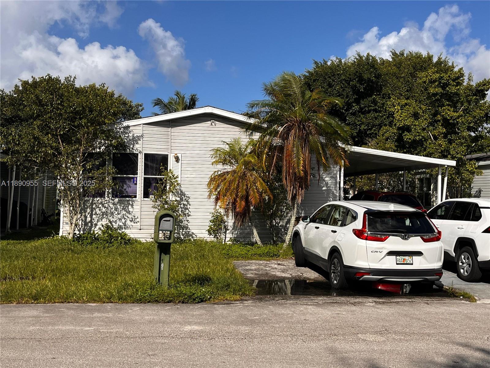 909 Southwest 131st Way Davie, FL 33325 - Photo 6 of 36 a car parked in front of white house