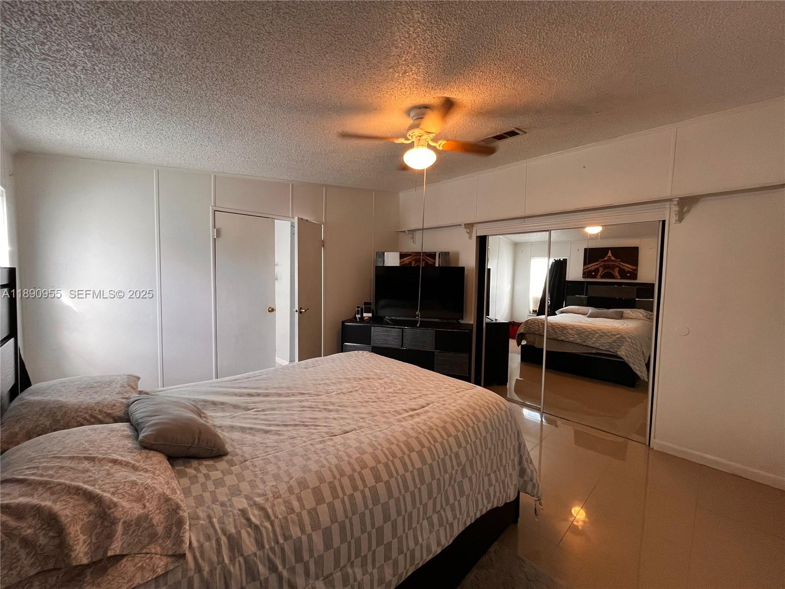 909 Southwest 131st Way Davie, FL 33325 - Photo 9 of 36 a bedroom with a bed and a chandelier