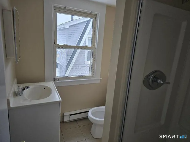 a bathroom with a toilet sink and window