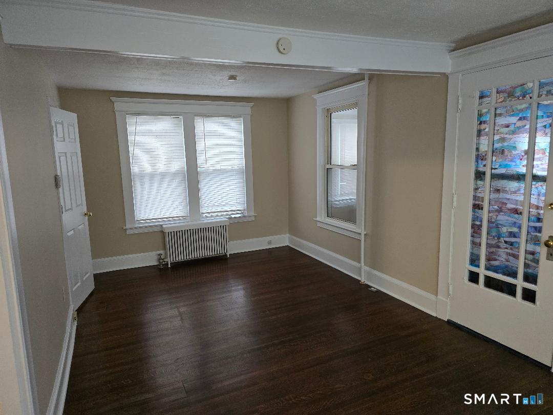 39 Lockhart Avenue Waterbury, CT 06705 - Photo 6 of 14 an empty room with wooden floor and windows