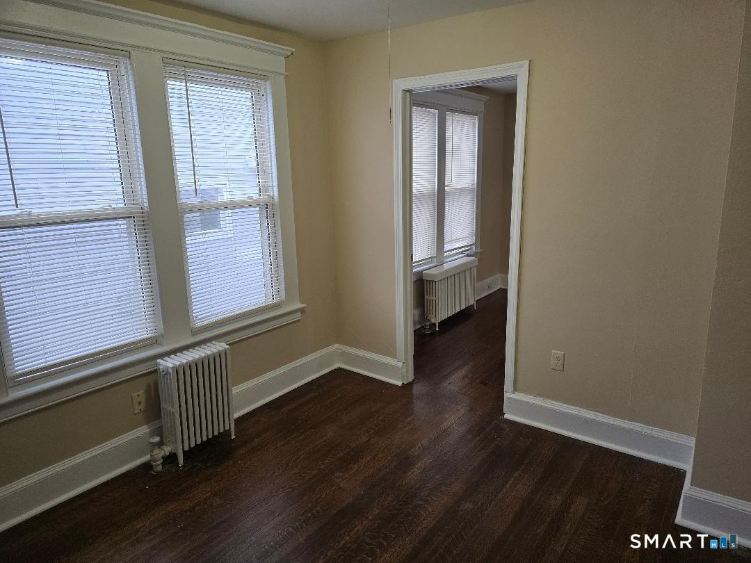 39 Lockhart Avenue Waterbury, CT 06705 - Photo 7 of 14 an empty room with wooden floor and windows