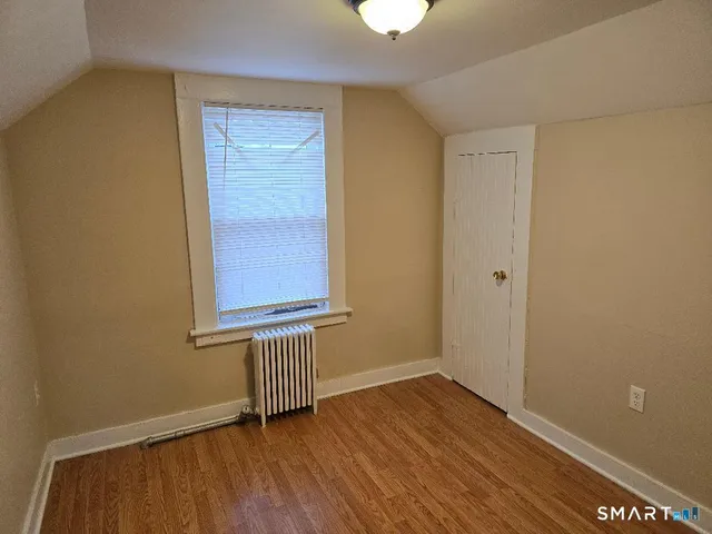 a view of a small space with wooden floor and a window