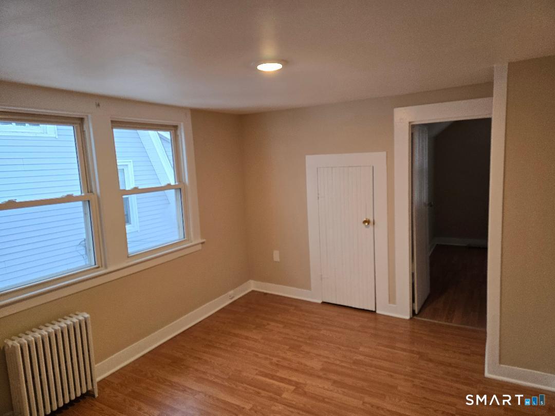 39 Lockhart Avenue Waterbury, CT 06705 - Photo 10 of 14 a view of an empty room with wooden floor and a window