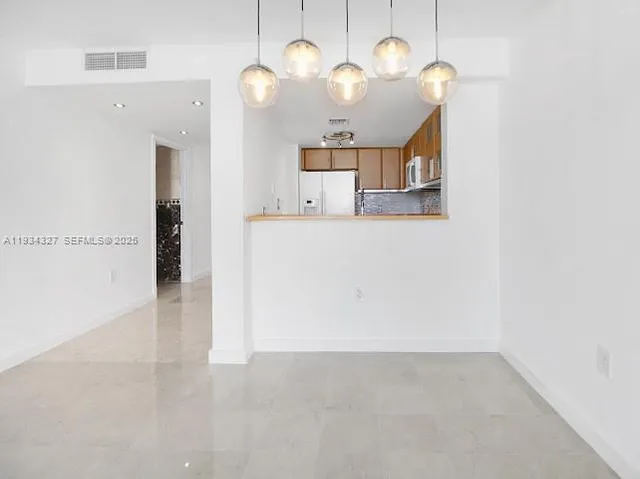 a view of a big room with wooden floor and windows