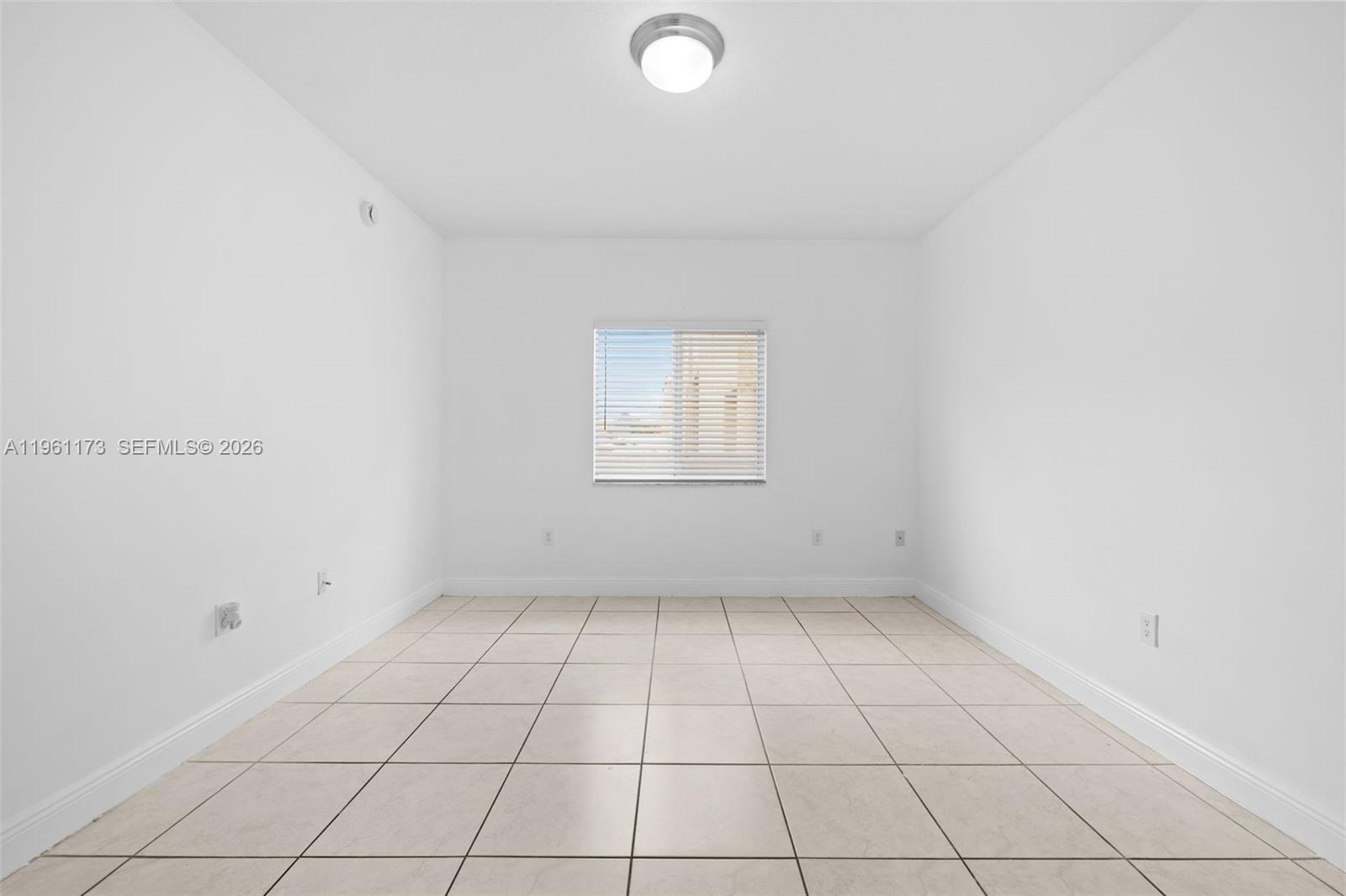 2437 West 78th Street, Unit 104 Hialeah, FL 33016 - Photo 13 of 21 an empty room with white walls and tiles