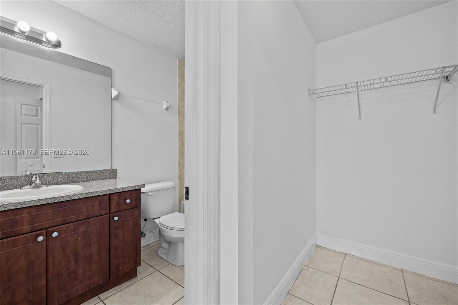 2437 West 78th Street, Unit 104 Hialeah, FL 33016 - Photo 20 of 21 a bathroom with a granite countertop sink a toilet and a mirror