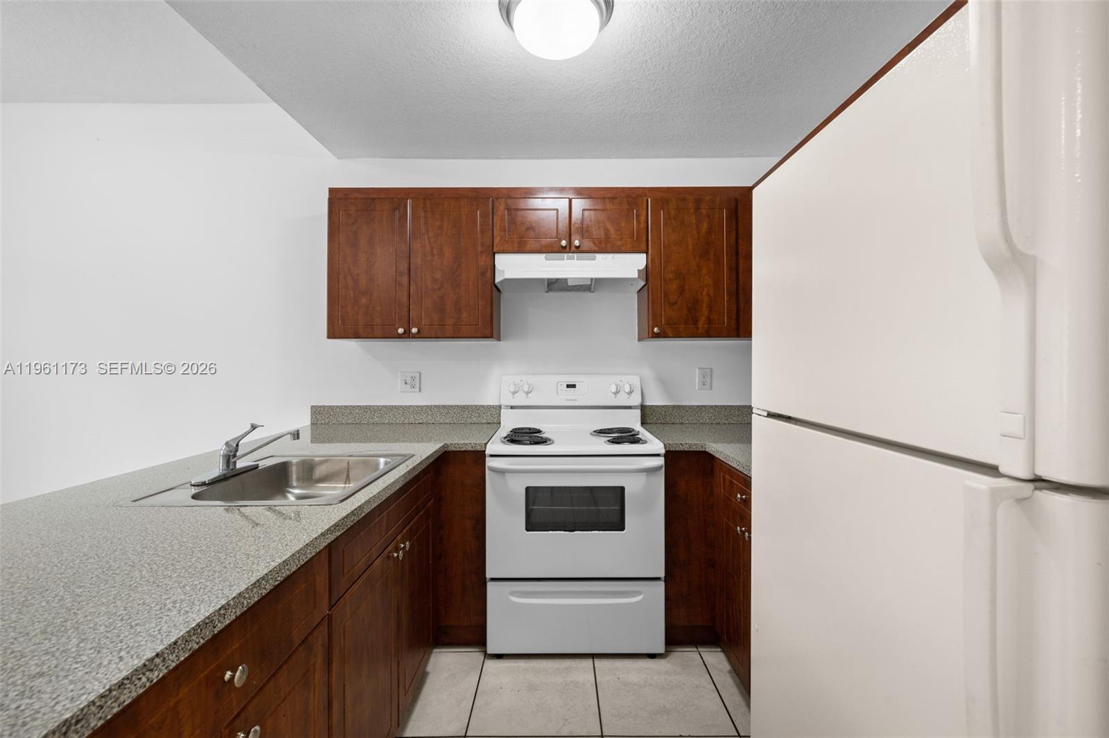 2437 West 78th Street, Unit 104 Hialeah, FL 33016 - Photo 2 of 21 a kitchen with a stove and a refrigerator