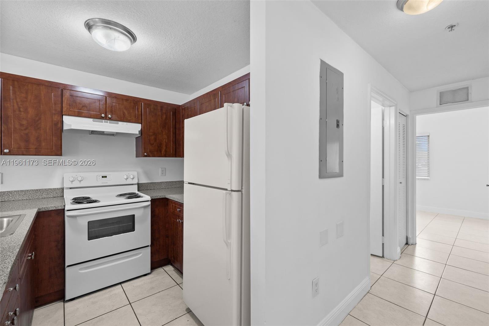 2437 West 78th Street, Unit 104 Hialeah, FL 33016 - Photo 3 of 21 a kitchen with a stove a refrigerator and a sink