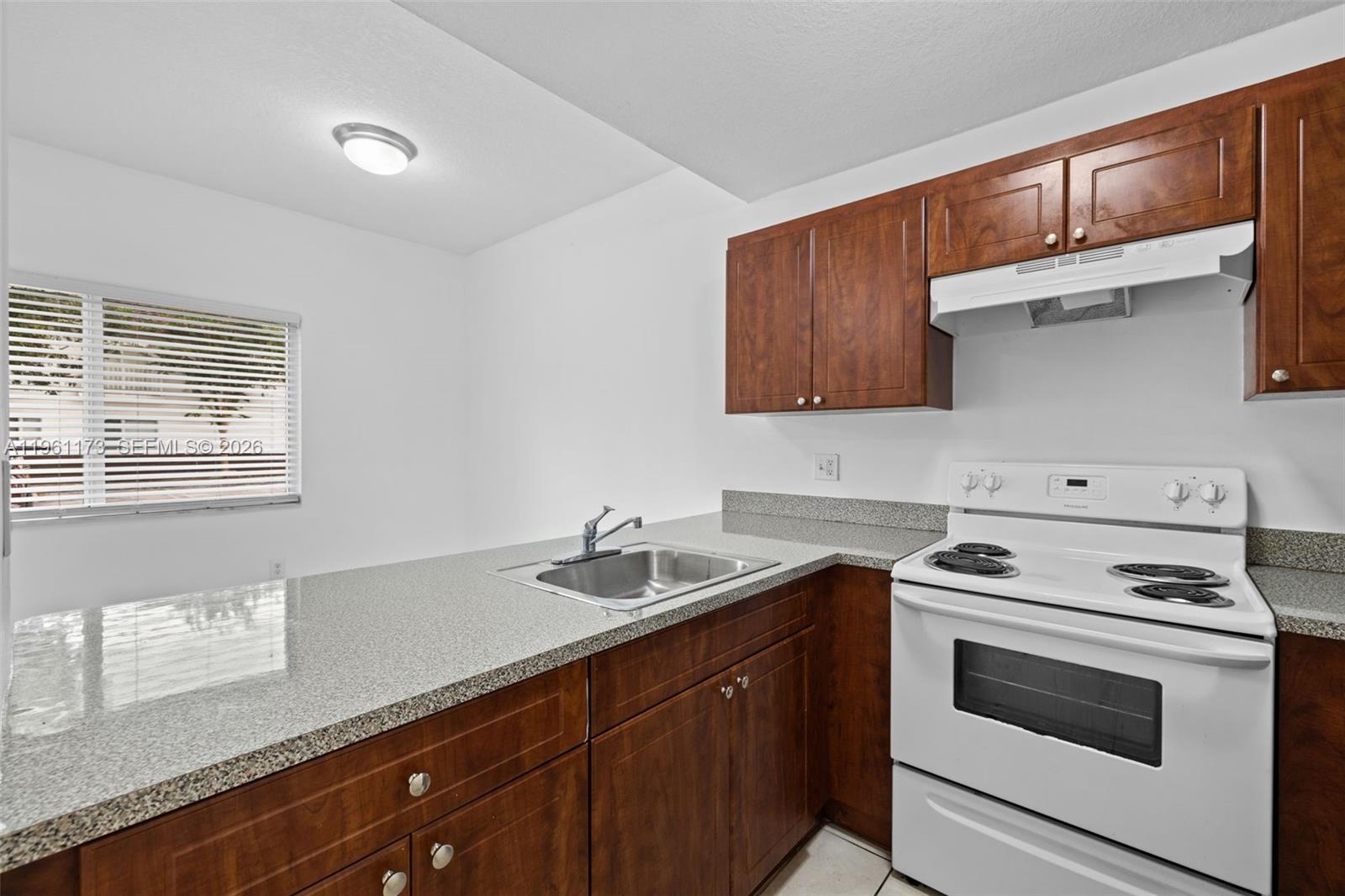 2437 West 78th Street, Unit 104 Hialeah, FL 33016 - Photo 5 of 21 a kitchen with a sink stove and cabinets