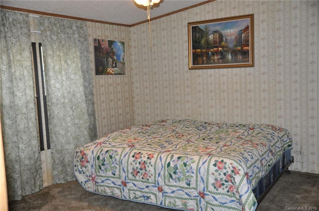 2919 Belk Mill Road Wingate, NC 28174 - Photo 17 of 24 a bedroom with a bed and painting on the wall