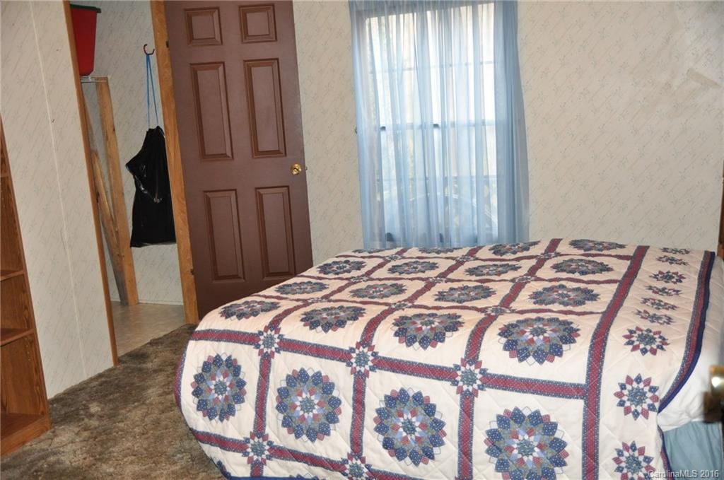 2919 Belk Mill Road Wingate, NC 28174 - Photo 22 of 24 a bedroom with a bed and a mirror
