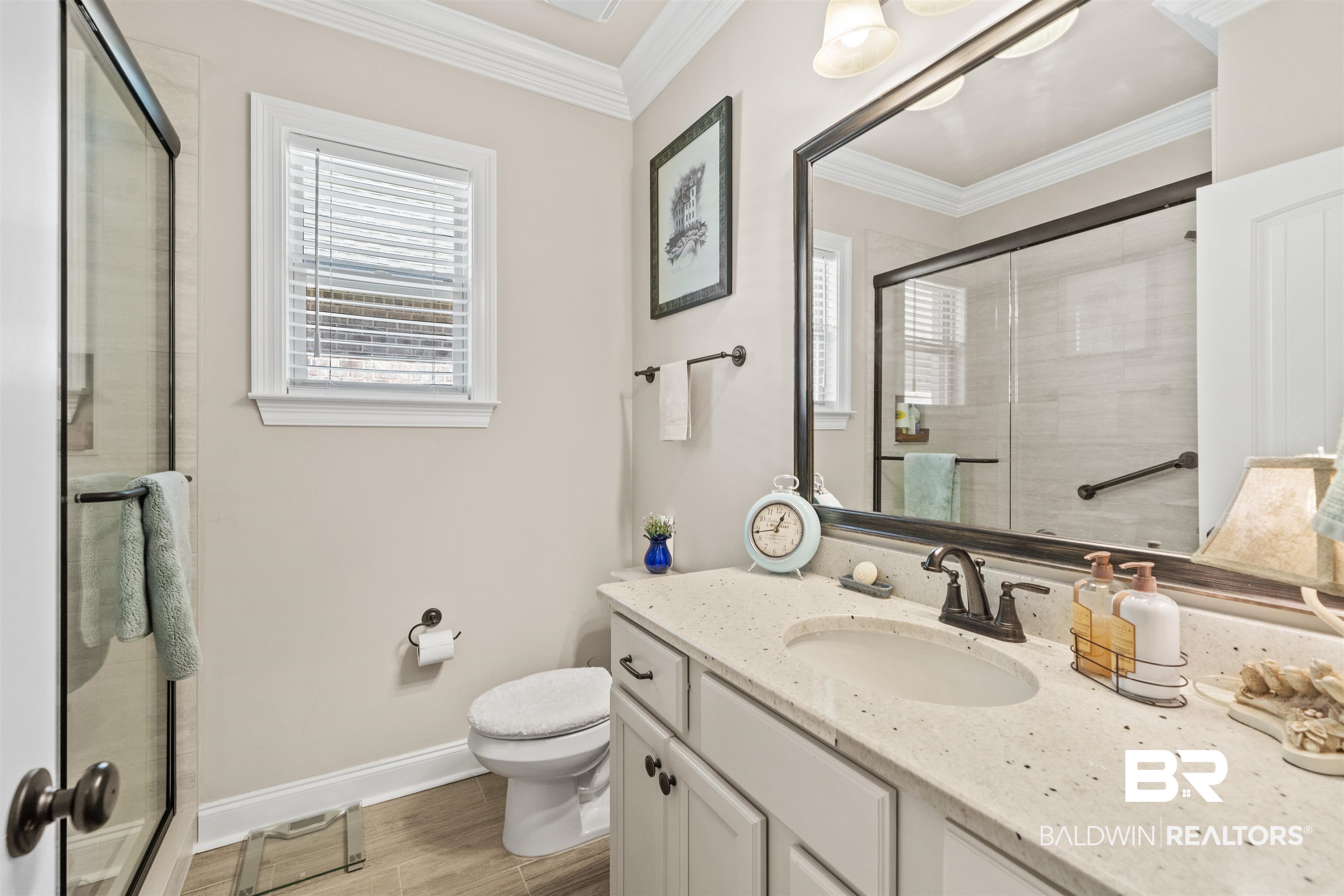 1509 Fenton Circle Foley, AL 36535 - Photo 19 of 34 Bathroom featuring wood finished floors, toilet, crown molding, and a shower stall
