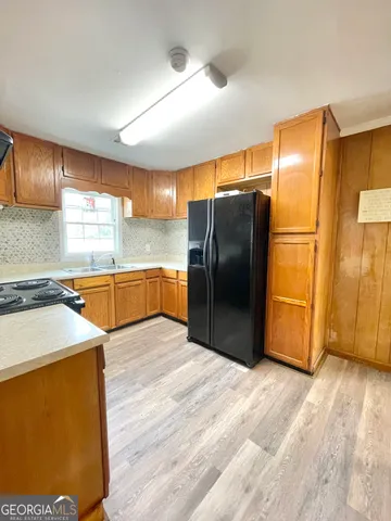 a kitchen with stainless steel appliances wooden floor and a large window