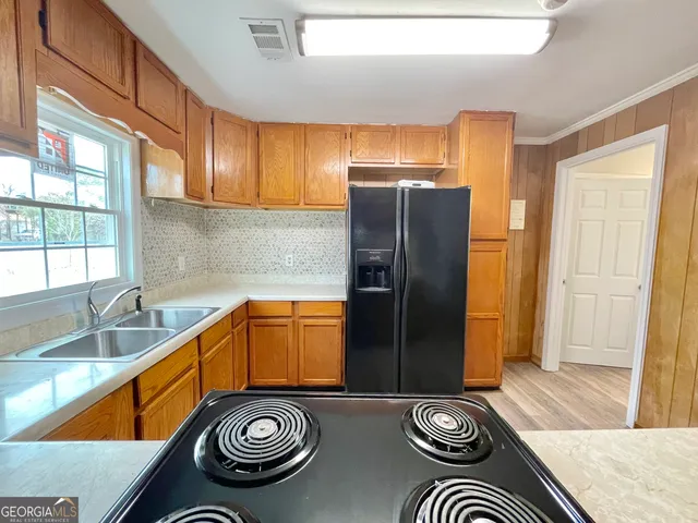 a kitchen with stainless steel appliances granite countertop a refrigerator and a sink