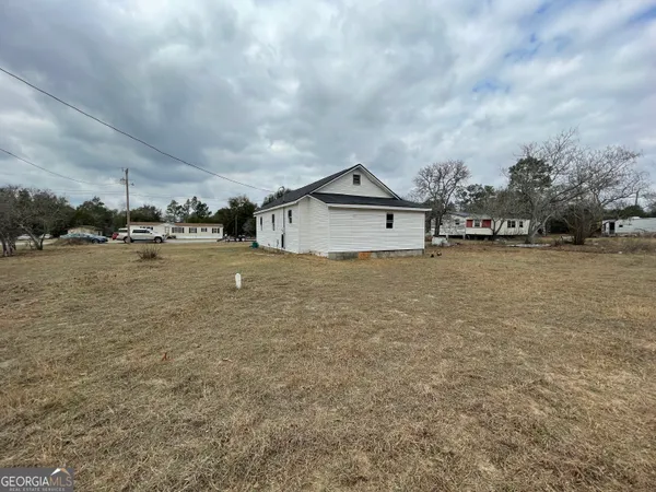 a view of a house with a yard and sitting area