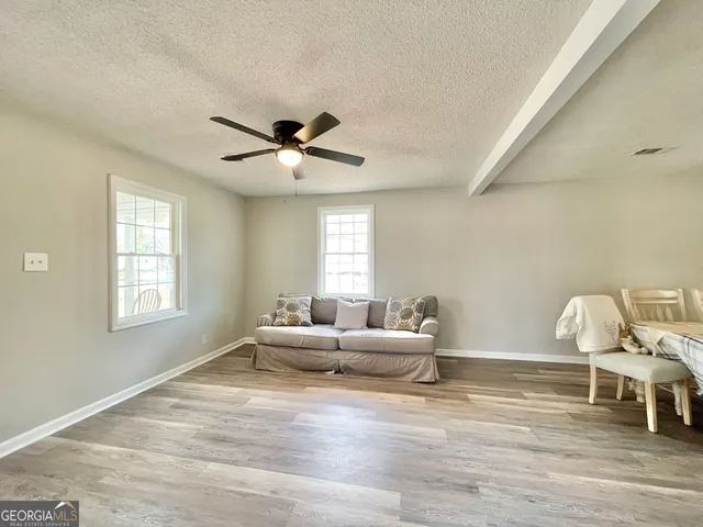 a living room with furniture wooden floor and a window