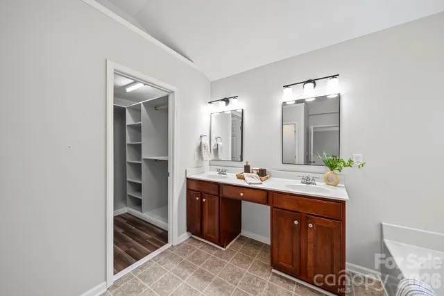 a spacious bathroom with a double vanity sink and mirror