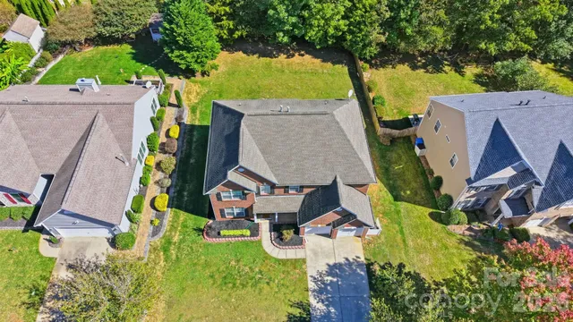 an aerial view of a house with a yard and swimming pool