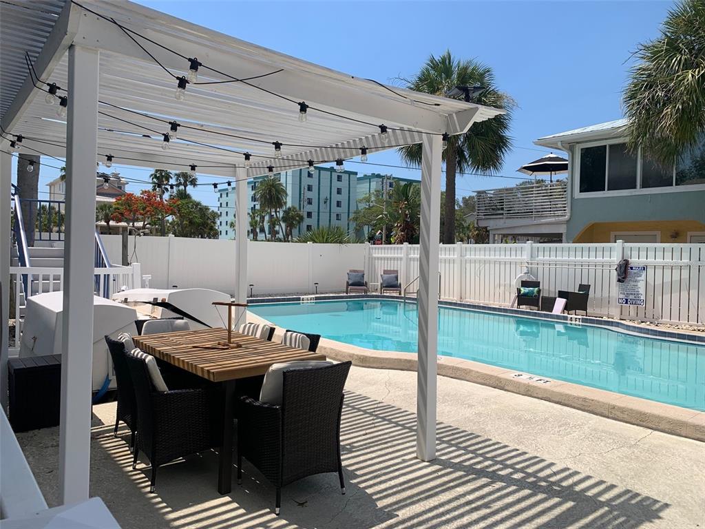 2308 1st Street, Unit 4 Indian Rocks Beach, FL 33785 - Photo 23 of 25 a view of a patio with table and chairs and potted plants