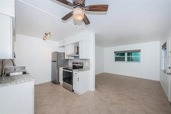 a kitchen with stainless steel appliances granite countertop a stove a sink and a refrigerator