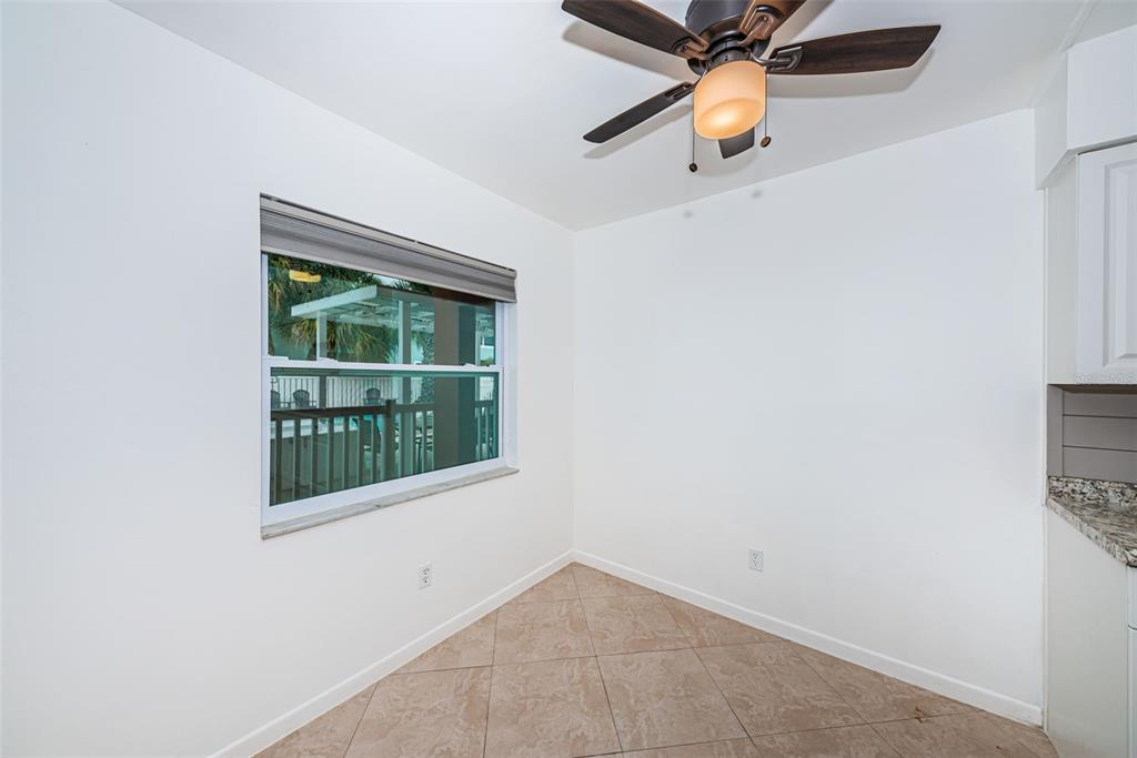 2308 1st Street, Unit 4 Indian Rocks Beach, FL 33785 - Photo 9 of 25 an empty room with window and chandelier fan