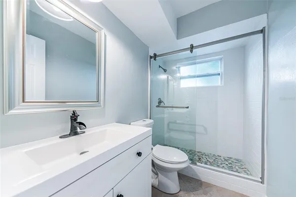 a bathroom with a sink a toilet and shower