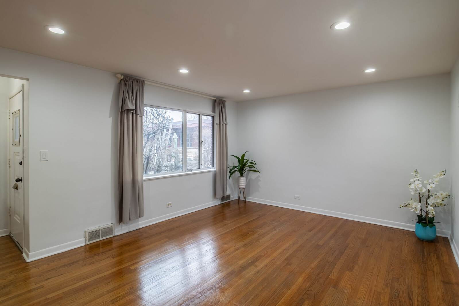 243 Custer Avenue Evanston, IL 60202 - Photo 3 of 31 a view of an empty room with wooden floor and a window