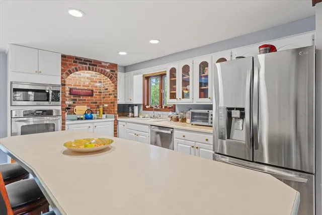 a kitchen with a refrigerator a stove and a cabinets with wooden floor