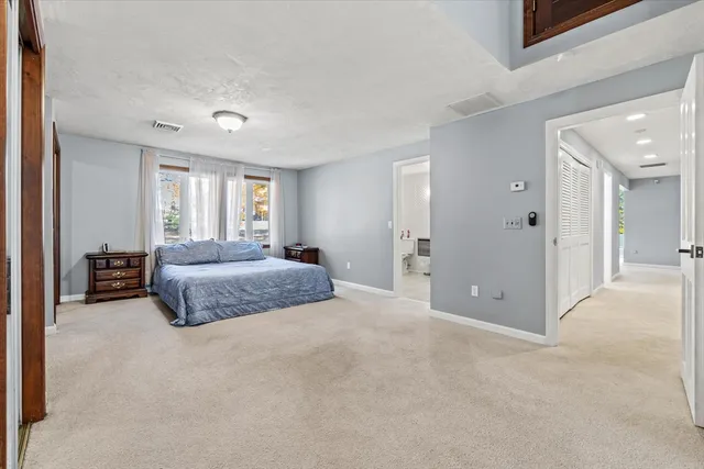 a spacious bedroom with a bed and a cabinets