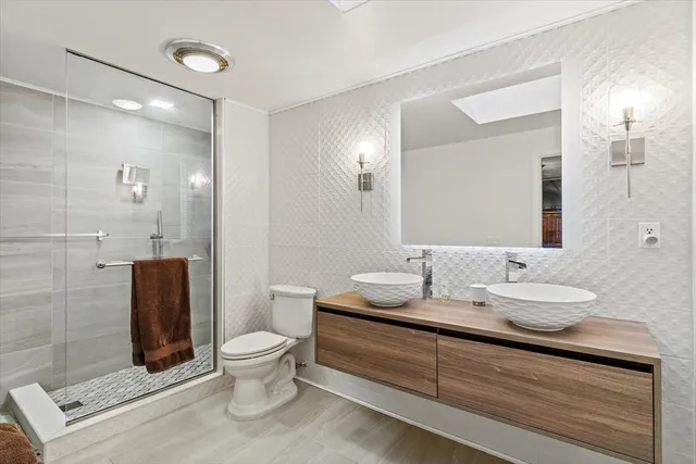 a bathroom with a double vanity sink toilet and shower