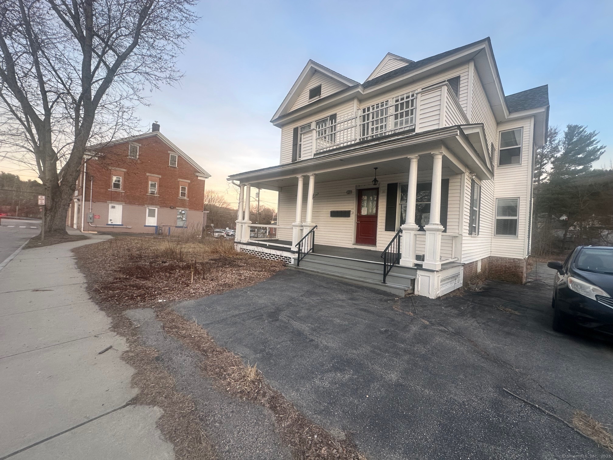 12 West Main Street Sprague, CT 06330 - Photo 2 of 35 a view of a white house with large windows and a small yard