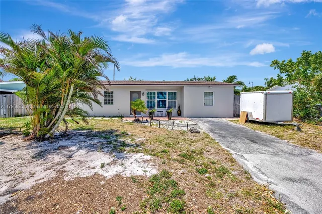 a view of a house with backyard and tree
