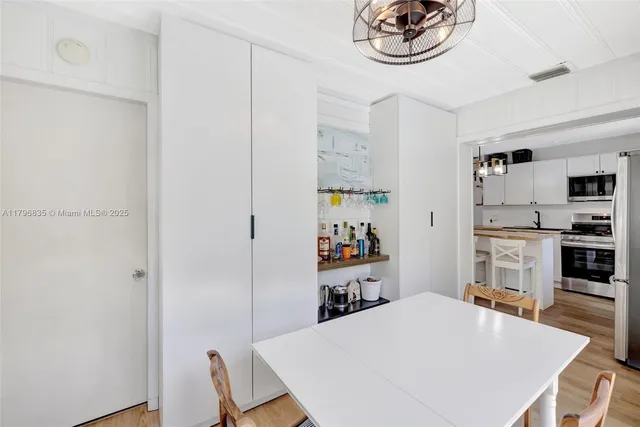 a kitchen with stainless steel appliances a table and chairs in it