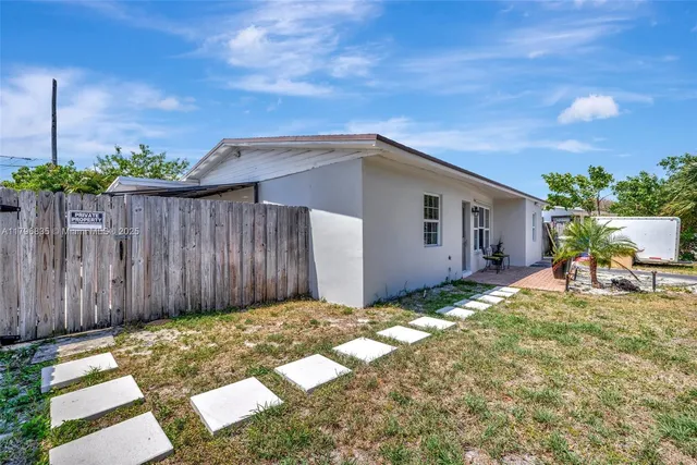 a backyard of a house with table and chairs