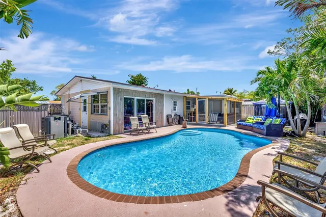 a view of a house with swimming pool and sitting area