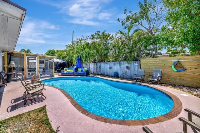 a swimming pool with outdoor seating and yard