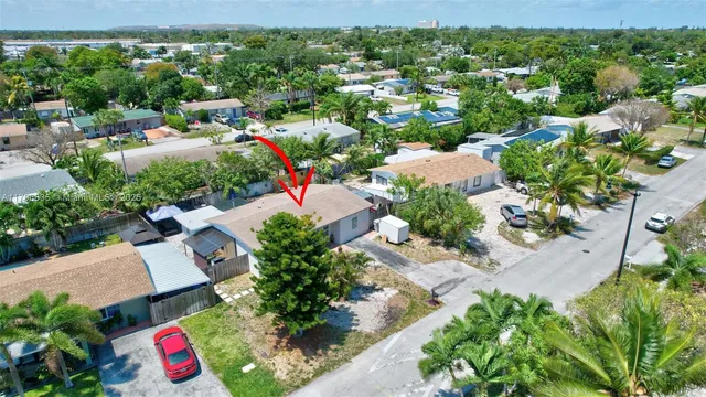 an aerial view of residential house with outdoor space and trees all around